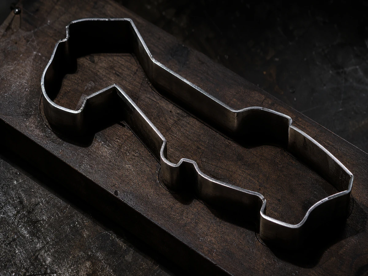 A steel cutting die with its blade following a shaped outline