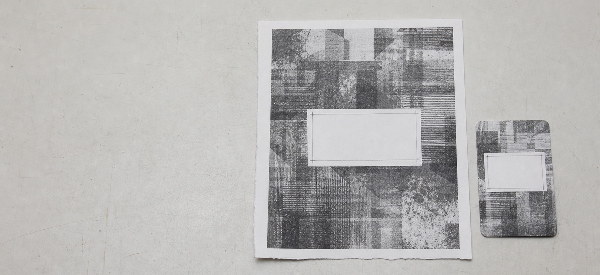 A finished RFID label lying flat beside an artwork proof on a make-ready bench, the blank area on each aligned on the same line