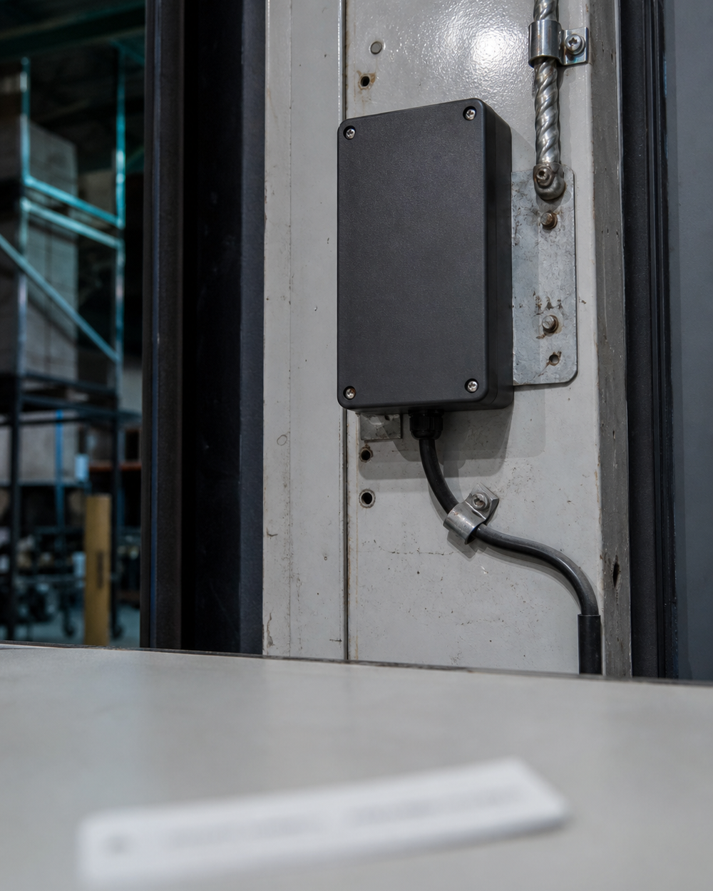 A reading installation already mounted on a warehouse doorway with its cabling run in, an unapplied label soft in the foreground